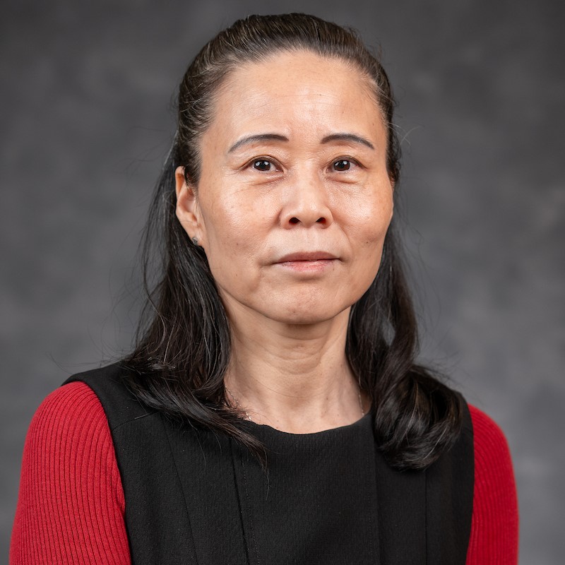 Woman with pulled-back hair partially smiling